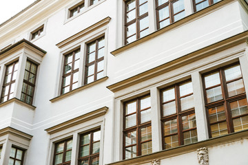 Photo of a white stoned building, classical architecture and wooden windows made in daytime.
