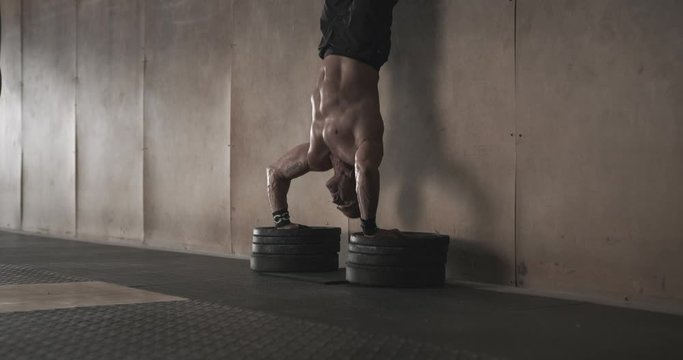 Man doing handstand push ups in gym