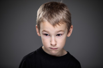 Grief-stricken little boy - feeling intense sorrow, remorse, sadnesss - studio portrait - vivid emotions series