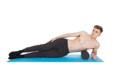 Handsome man shows exercises using a foam roller