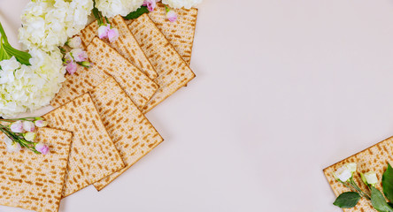 Background of matzah bread with flowers. Jewish Passover holiday concept.