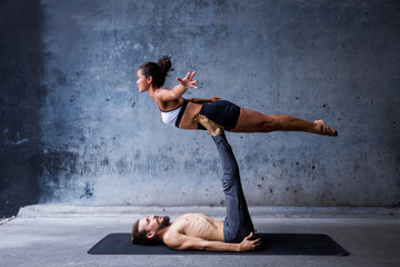 Fototapeta na wymiar Latin couple practice acroyoga together. Concept of trust and support. 