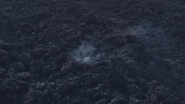 Explosion on the surface of the earth from an explosive device, hit by a shell or ammunition, the texture of smoke and flying soil from the shock wave in slow motion, the soil during combat