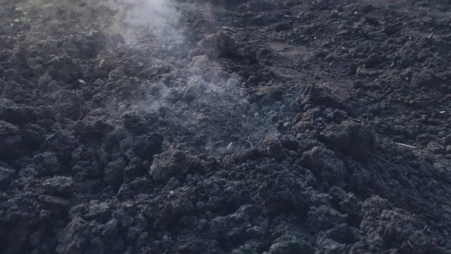 Explosion on the surface of the earth from an explosive device, hit by a shell or ammunition, the texture of smoke and flying soil from the shock wave in slow motion, the soil during combat