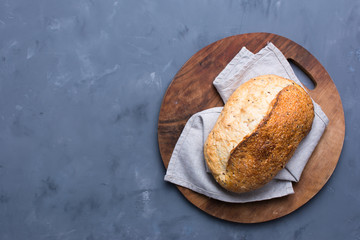 Fresh homemade crisp bread with seed flax on wood round board. Concept for bunner, top view on grey background.