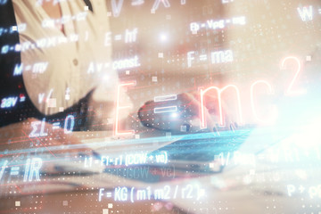 Double exposure of woman hands typing on computer and formula hologram drawing. Education concept.