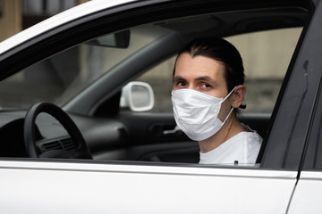 Fototapeta na wymiar Man in protective medical mask for protect himself from bacteria and virus is planning to drive a car. Protective mask while epidemic, quarantine, world pandemic, covid 19, coronavirus, infection.