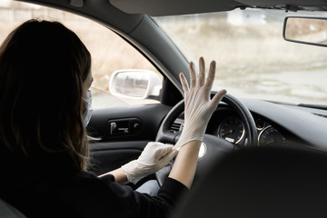 Fototapeta na wymiar Woman in protective medical mask is wearing rubber gloves for protect himself from bacteria virus while planning to drive. Protective mask while quarantine, pandemic, covid 19, coronavirus, infection.