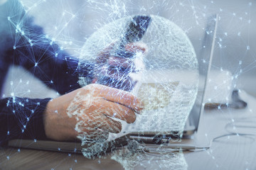 Double exposure of man's hand holding and using a digital device and brain hologram drawing. Data concept.