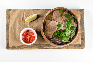 Asian soup in a wooden plate, pho bo soup, flat lay