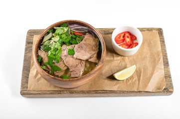 Fototapeta na wymiar Asian soup in a wooden plate, pho bo soup. Flat lay