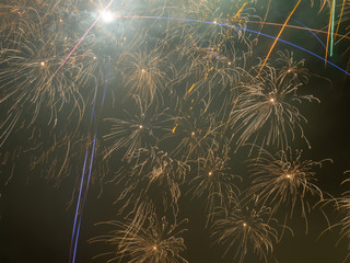 Photos of a large number of bright fireworks in the dark clouded sky