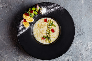 Oatmeal with berries, fruits and marmalade on vintage teal table top view in flat lay style. Hot and healthy breakfast and diet food.