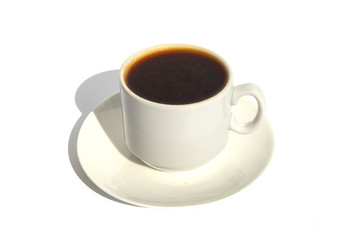 A small cup of espresso on a saucer in the sun
