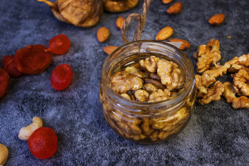 Jar with honey and nuts, on a white background