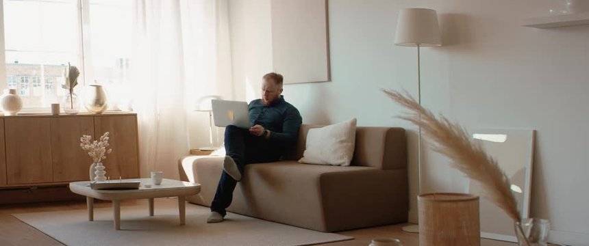 Mid 30s Caucasian male working from home, checking documents, making notes. Stay home, quarantine remote work. Shot on RED Dragon