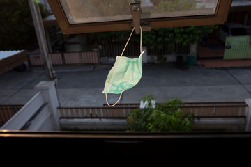 Fototapeta na wymiar Hygienic mask hanging sunbathing at window after the used and washing,Hang mask on window getting UV from sunshine to kill virus and bacteria
