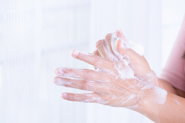 Closeup woman washing hands with soap on white background. Healthcare and disinfection concept.