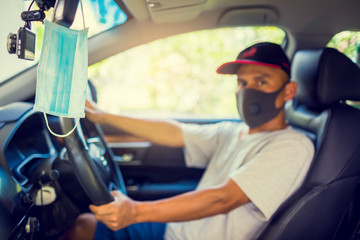 Hygienic masks hanging on rear view mirror with blurry driver. Daily preparation for the prevention of Coronavirus Covid-19 and PM2.5. The concept of Coronavirus Covid-19 and PM2.5 protection.