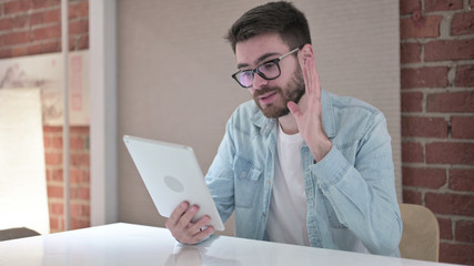 Cheerful Young Man in Glasses doing Video Chat on Tablet