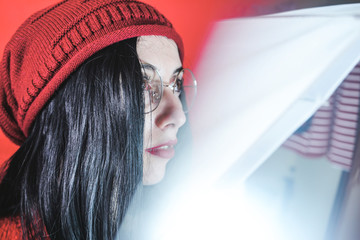 Studio artistic portrait of a brunette woman against red  background
