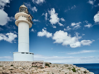 Lighthouse on the Formentera island, Spain, the blue sky with white clouds, without people, rocks,...