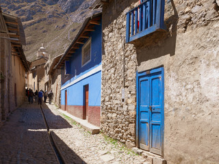 Fototapeta na wymiar Street view of traditional houses with wooden doors and balcony in Huancaya town at a sunny day in Lima Region, Peru