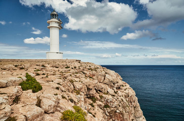 Lighthouse on the Formentera island, Spain, the blue sky with white clouds, without people, rocks, stones, sunny weather