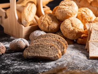 group of bread on the black wooden table with sunlight
