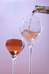 Pouring rose wine into wine glasses.
