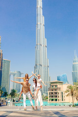 Famille heureuse marchant à Dubaï avec des gratte-ciel en arrière-plan.