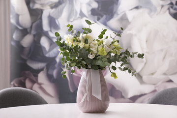 Vase with beautiful bouquet on white table indoors. Stylish interior element