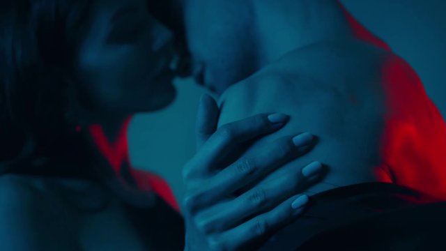 rack focus of woman touching muscular man on blue