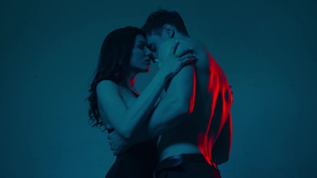 sensual woman touching shirtless man on blue