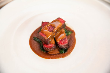 Sliced of expensive beef steak meat with sauce and vegetables.