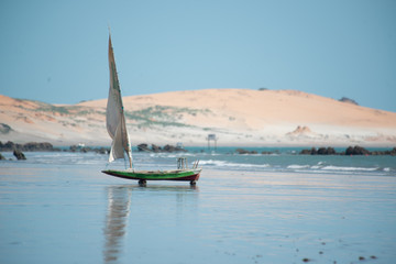 Colorful cliffs, dunes and small sailing boat early morning on the beach of Peroba, Icapui,...