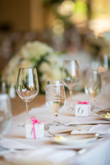 Wedding table setting with ice water filled glass and small gift boxes for the guests