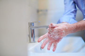 Fototapeta premium coronavirus male wahing hands in bathroom