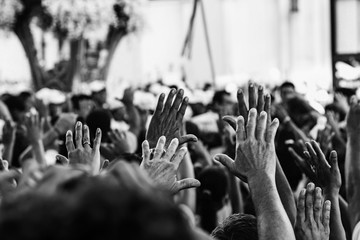 Mãos erguidas de pessoas. Multidão em procissão religiosa. Muitas mãos levantadas.