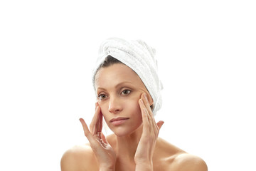 Facial massage at home, raising the tone of the cheeks, smoothing wrinkles. Beautiful young woman with a white towel on her head and with clean perfect skin. Isolated white background.