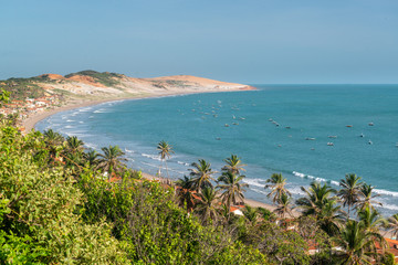 Early morning view of Praia de Peroba, Icapui, Ceará, Brazil with small fishing boats and dune...