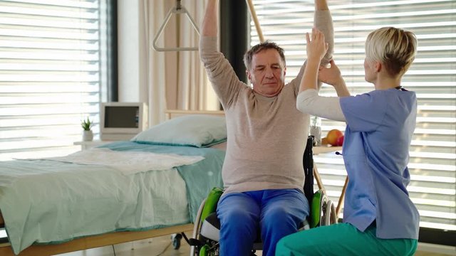 Healthcare worker and senior patient in wheelchair in hospital, physiotherapy.