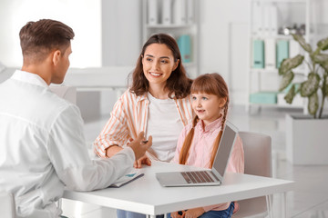 Woman with little daughter visiting pediatrician in clinic