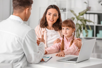 Woman with little daughter visiting pediatrician in clinic
