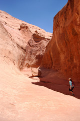 Hiker in a slot canyon in the North wash canyon country of Southern Utah.