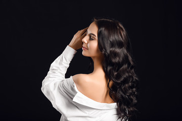 Obraz premium Young woman with beautiful healthy hair on dark background