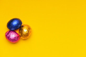 Sweet chocolate eggs on color background