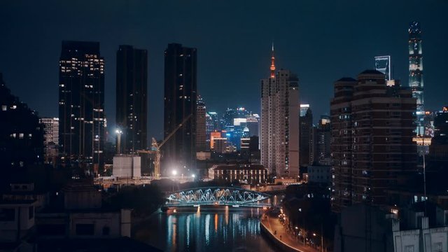 Night view over Shanghai skylines with neon and reflection glowing in the dark. April 2020.