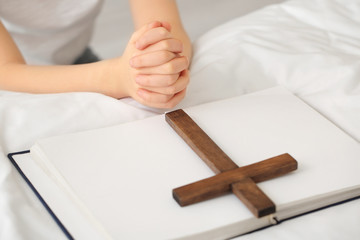 Cute little girl praying at home, closeup