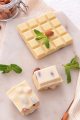 Sweet white chocolate with nuts and mint on table